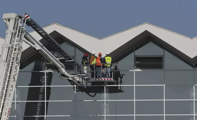 Workers inspect a train station after an outdoor roof collapsed in Novi Sad, Serbia, Saturday, Nov. 2, 2024. (AP Photo/Darko Vojinovic)