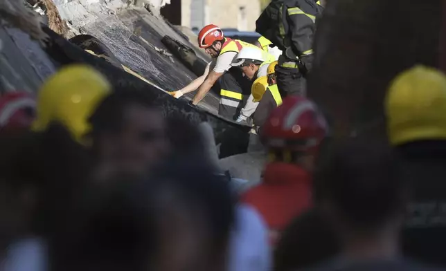 Rescue workers search for victims in the aftermath of an outdoor roof collapse at a train station in Novi Sad, Serbia, Friday, Nov. 1, 2024. (AP Photo)