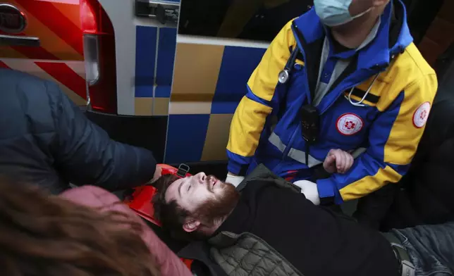 Demonstrators and paramedics carry a wounded after the clashes between police and protesters to an ambulance on a street during a rally against the results of the parliamentary elections amid allegations that the vote was rigged in Tbilisi, Georgia, on Tuesday, Nov. 19, 2024. (AP Photo/Zurab Tsertsvadze)