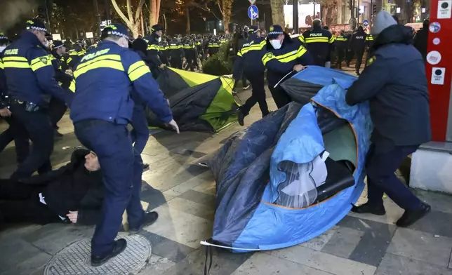 Police remove protesters’ tent camp on a street during a rally against the results of the parliamentary elections amid allegations that the vote was rigged in Tbilisi, Georgia, on Tuesday, Nov. 19, 2024. (AP Photo/Zurab Tsertsvadze)