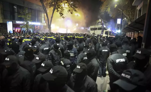 Police gather to push protesters away from a street during a rally against the results of the parliamentary elections amid allegations that the vote was rigged in Tbilisi, Georgia, on Tuesday, Nov. 19, 2024. (AP Photo/Zurab Tsertsvadze)