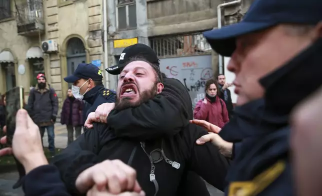 Police try to detain a protester on a street during a rally against the results of the parliamentary elections amid allegations that the vote was rigged in Tbilisi, Georgia, on Tuesday, Nov. 19, 2024. (AP Photo/Zurab Tsertsvadze)