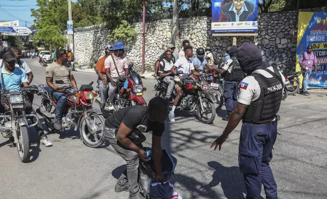 Police officers man a checkpoint checking for weapons, in the Petion-Ville of Port-au-Prince, Haiti, Tuesday, Nov. 19, 2024. (AP Photo/Odelyn Joseph)