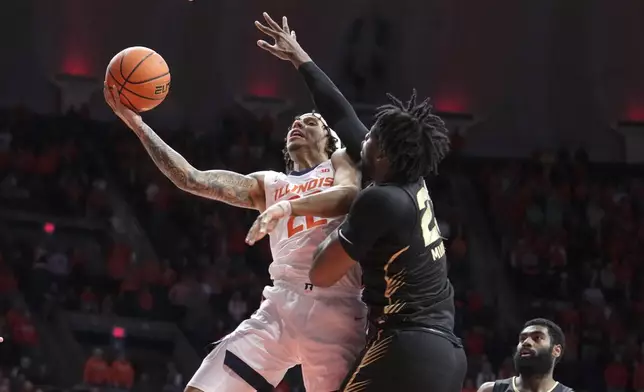 Illinois's Tre White (22) drives to the basket as Oakland's Allen Mukeba defends during the first half of an NCAA college basketball game Wednesday, Nov. 13, 2024, in Champaign, Ill. (AP Photo/Charles Rex Arbogast)