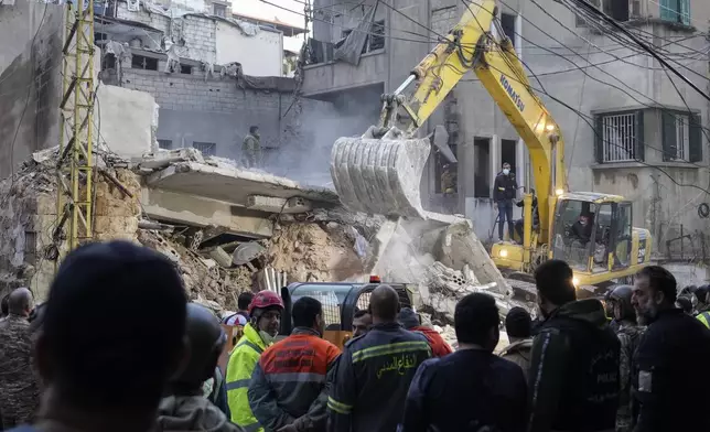 Rescuers use an excavator as they search for victims at the site of an Israeli airstrike that hit a building in Beirut, Tuesday, Nov. 26, 2024. (AP Photo/Hassan Ammar)