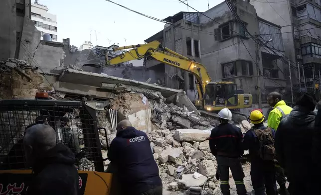 Rescuers use an excavator as they search for victims at the site of an Israeli airstrike that hit a building in Beirut, Lebanon, Tuesday, Nov. 26, 2024. (AP Photo/Hassan Ammar)