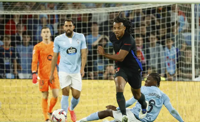 Barcelona's Jules Kounde, front, goes for the ball during the Spanish La Liga soccer match between Celta Vigo and Barcelona at the Balaidos stadium in Vigo, Spain, Saturday, Nov. 23, 2024. (AP Photo/Lalo R. Villar)