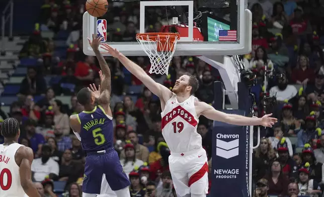 New Orleans Pelicans guard Dejounte Murray (5) shoots against Toronto Raptors center Jakob Poeltl (19) in the first half of an NBA basketball game in New Orleans, Wednesday, Nov. 27, 2024. (AP Photo/Gerald Herbert)