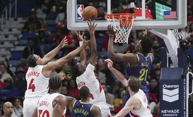 Toronto Raptors guard Ja'Kobe Walter and forward Scottie Barnes (4) leap for a rebound against New Orleans Pelicans center Yves Missi (21) in the first half of an NBA basketball game in New Orleans, Wednesday, Nov. 27, 2024. (AP Photo/Gerald Herbert)