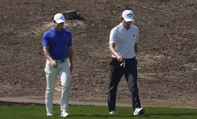 Rory McIlroy of Northern Ireland, left, and Rasmus Højgaard of Denmark walk to take their second shot on 4th hole in the final round of World Tour Golf Championship in Dubai, United Arab Emirates, Sunday, Nov. 17, 2024. (AP Photo/Altaf Qadri)