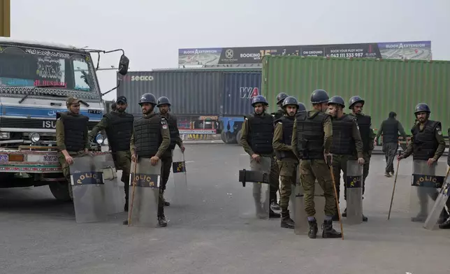 Police officers stand guard on an entry point to motorway leading to Islamabad, which has been closed by authorities due to a planned rally by supporters of imprisoned former Prime Minister Imran Khan's Pakistan Tehreek-e-Insaf party, in Lahore, Pakistan, Saturday, Nov. 23, 2024. (AP Photo/K.M. Chaudary)