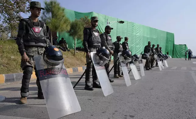 Paramilitary soldiers stand guard with riot gears at a road barricaded with shipping containers ahead of a planned rally by supporters of imprisoned former Prime Minister Imran Khan's Pakistan Tehreek-e-Insaf party, in Islamabad, Pakistan, Sunday, Nov. 24, 2024. (AP Photo/Anjum Naveed)