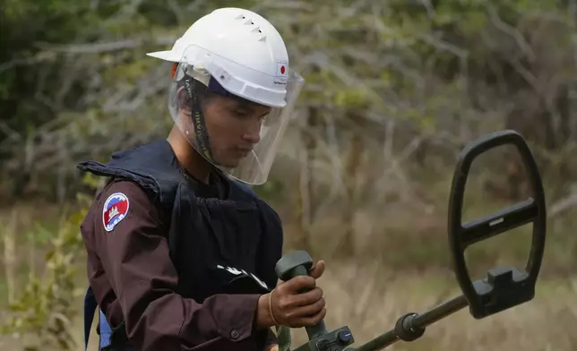 A Cambodian Mine Action Center, CMAC, staff member checks a mine detector at a minefield in Preytotoeung village, Battambang province, Cambodia, Thursday, Jan. 19, 2023. (AP Photo/Heng Sinith)