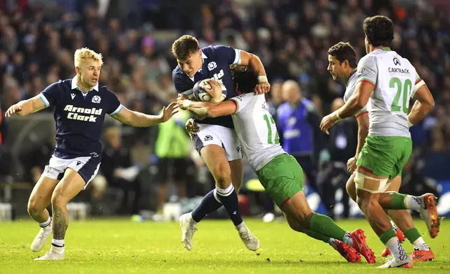 Scotland's Tom Jordan, center, is tackled by Portugal's Tomas Appleton during the Autumn Nations series rugby union match between Scotland and Portugal at the Scottish Gas Murrayfield Stadium, in Edinburgh, Scotland, Saturday Nov. 16, 2024. (Jane Barlow/PA via AP)