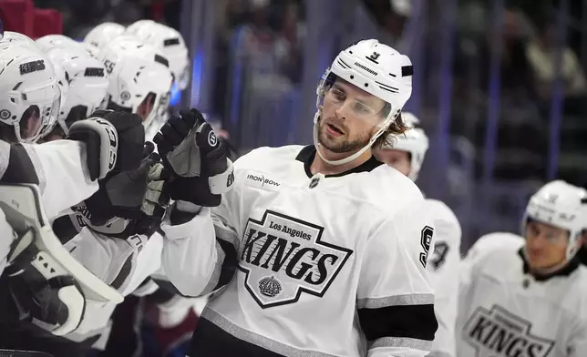 Los Angeles Kings right wing Adrian Kempe is congratulated as he passes the team box after scoring a goal against the Colorado Avalanche in the first period of an NHL hockey game Wednesday, Nov. 134, 2024, in Denver. (AP Photo/David Zalubowski)