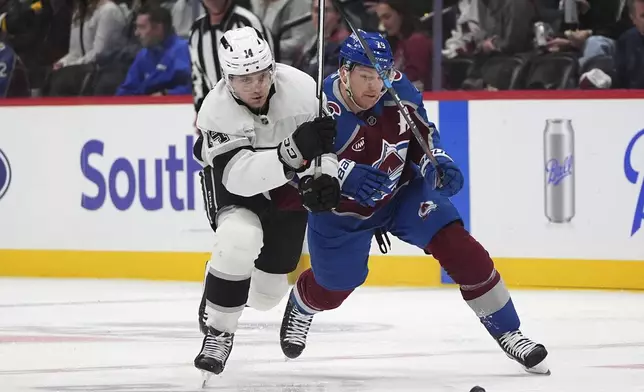 Los Angeles Kings right wing Alex Laferriere, left, pursues the puck with Colorado Avalanche center Nathan MacKinnon in the second period of an NHL hockey game Wednesday, Nov. 13, 2024, in Denver. (AP Photo/David Zalubowski)