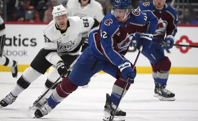 Colorado Avalanche defenseman Josh Manson, front, collects the puck as Los Angeles Kings center Trevor Lewis pursues in the second period of an NHL hockey game Wednesday, Nov. 13, 2024, in Denver. (AP Photo/David Zalubowski)