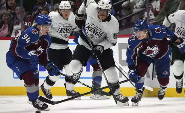 Los Angeles Kings right wing Quinton Byfield, center, drives between Colorado Avalanche left wing Joel Kiviranta, left, and center Parker Kelly in pursuit of the puck in the second period of an NHL hockey game Wednesday, Nov. 13, 2024, in Denver. (AP Photo/David Zalubowski)