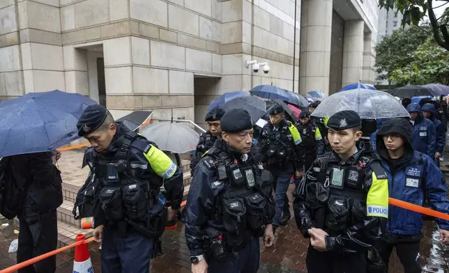 Police stand guard outside the West Kowloon Magistrates' Courts in Hong Kong, Wednesday, Nov. 20, 2024. (AP Photo/Chan Long Hei)