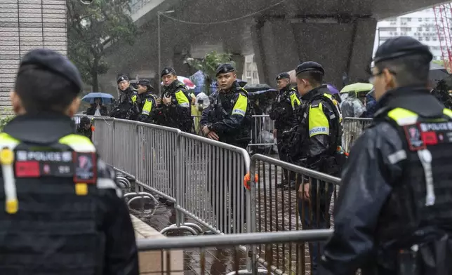 Police stand guard outside the West Kowloon Magistrates' Courts in Hong Kong, Wednesday, Nov. 20, 2024. (AP Photo/Chan Long Hei)