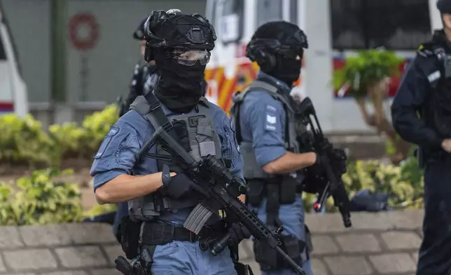 Armed police stand guard outside the West Kowloon Magistrates' Courts in Hong Kong, Wednesday, Nov. 20, 2024. (AP Photo/Chan Long Hei)