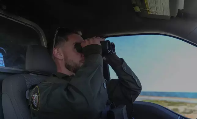 Conservation officer Sgt. Ian Van Nest scans the area for polar bears, Tuesday, Aug. 6, 2024, in Churchill, Manitoba. (AP Photo/Joshua A. Bickel)