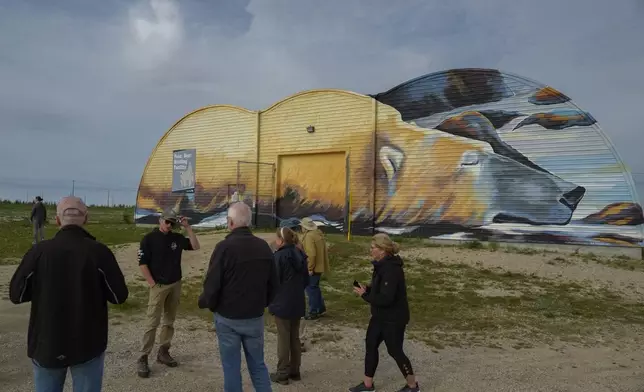 Tourists stand outside the Polar Bear Holding Facility, Sunday, Aug. 4, 2024, in Churchill, Manitoba. (AP Photo/Joshua A. Bickel)