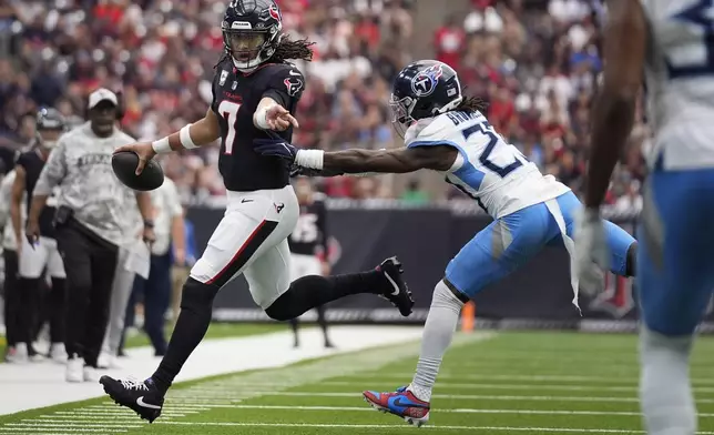 Houston Texans quarterback C.J. Stroud (7) runs past Tennessee Titans cornerback Jarvis Brownlee Jr. (29) during the first half of an NFL football game Sunday, Nov. 24, 2024, in Houston. (AP Photo/Ashley Landis)