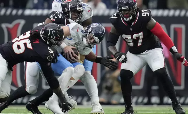 Houston Texans defenders Denico Autry (96), Danielle Hunter (55) and Mario Edwards Jr. (97) sack Tennessee Titans quarterback Will Levis (8) during the first half of an NFL football game Sunday, Nov. 24, 2024, in Houston. (AP Photo/Ashley Landis)