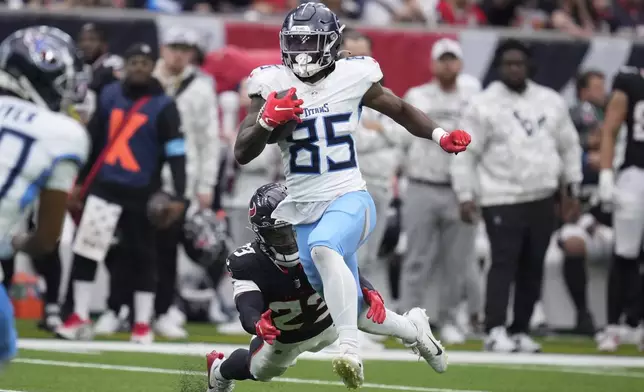 Tennessee Titans tight end Chig Okonkwo (85) runs past Houston Texans safety Eric Murray (23) after a catch to score a touchdown during the second half an NFL football game Sunday, Nov. 24, 2024, in Houston. (AP Photo/Eric Christian Smith)