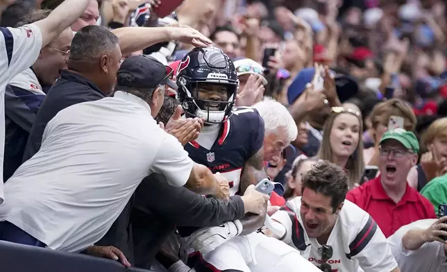 Houston Texans wide receiver Nico Collins (12) celebrates his touchdown with fans during the first half of an NFL football game against the Tennessee Titans, Sunday, Nov. 24, 2024, in Houston. (AP Photo/Eric Christian Smith)