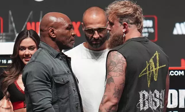 Mike Tyson, front left, and Jake Paul, front right, face off during a news conference ahead of their fight, Wednesday, Nov. 13, 2024, in Irving, Texas. (AP Photo/Julio Cortez)