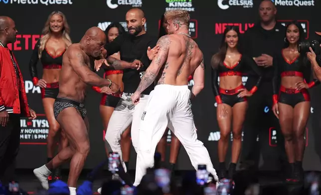 Mike Tyson, left, pushes on Jake Paul before slapping him during a weigh-in ahead of their heavyweight bout, Thursday, Nov. 14, 2024, in Irving, Texas. (AP Photo/Julio Cortez)