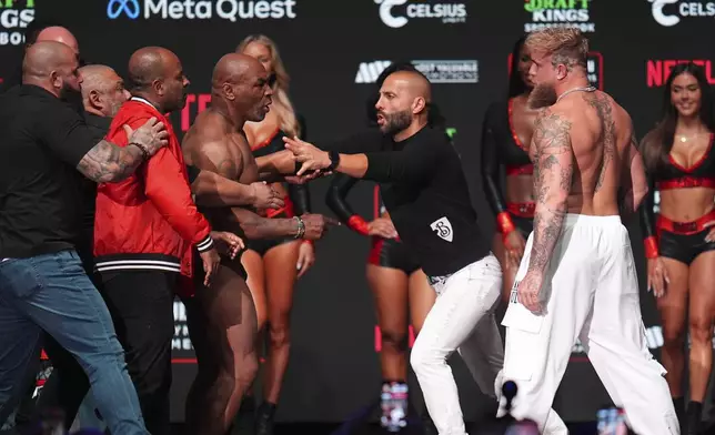Promoter Nakisa Bidarian, center, co-founder of Most Valuable Promotions, steps in the way of Mike Tyson, left, after Tyson slapped Jake Paul during a weigh-in ahead of their heavyweight bout, Thursday, Nov. 14, 2024, in Irving, Texas. (AP Photo/Julio Cortez)