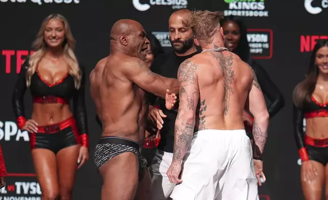 Mike Tyson, left, slaps Jake Paul during a weigh-in ahead of their heavyweight bout, Thursday, Nov. 14, 2024, in Irving, Texas. (AP Photo/Julio Cortez)