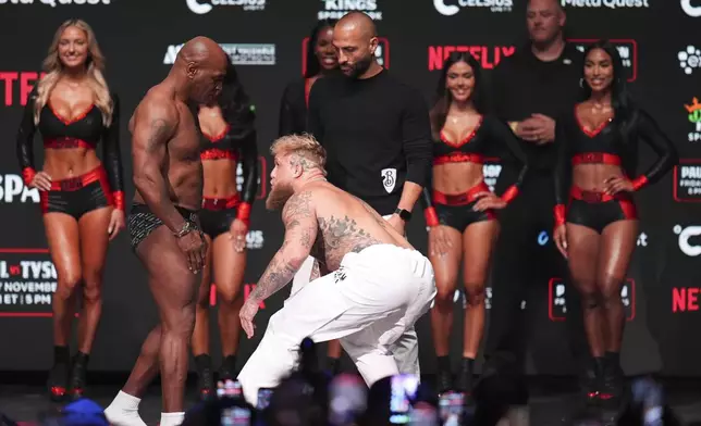 Jake Paul, right, approaches Mike Tyson during a weigh-in ahead of their heavyweight bout, Thursday, Nov. 14, 2024, in Irving, Texas. (AP Photo/Julio Cortez)