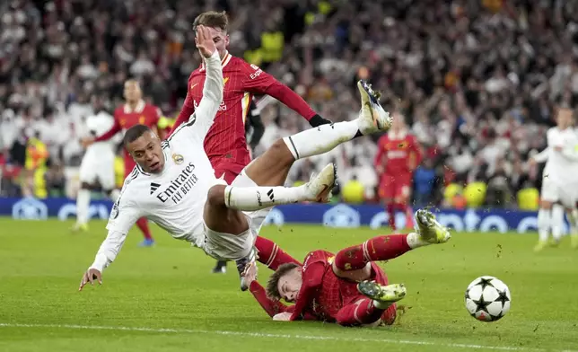 Liverpool's Conor Bradley tackles Real Madrid's Kylian Mbappe, left, during the Champions League opening phase soccer match between Liverpool and Real Madrid at Anfield Stadium, Liverpool, England, Wednesday, Nov. 27, 2024. (AP Photo/Jon Super)