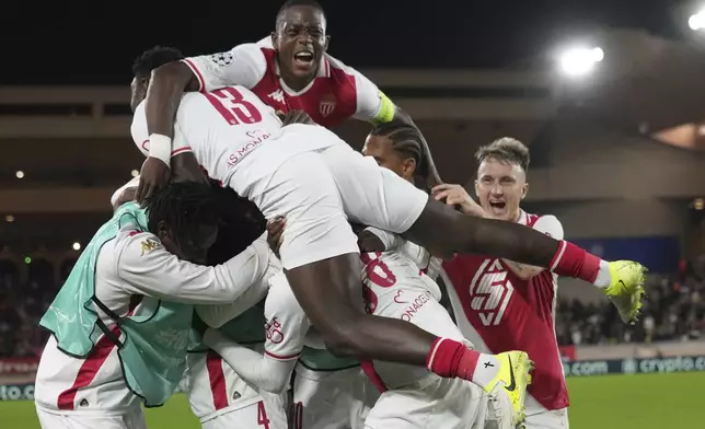 Monaco's players celebrate after their teammate Soungoutou Magassa scoring his side's 2nd goal against Benfica during a Champions League opening phase soccer match at the Louis II stadium in Monaco, Wednesday, Nov. 27, 2024. (AP Photo/Laurent Cipriani)