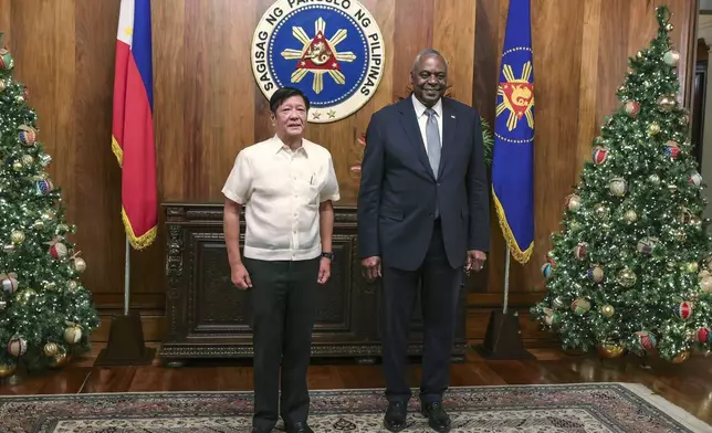 U.S. Defense Secretary Lloyd Austin, right, and Philippine President Ferdinand Marcos Jr. pose for a photograph during a courtesy call at the Malacanang Palace in Manila, Philippines Monday, Nov. 18, 2024. (AP Photo/Gerard Carreon, Pool)