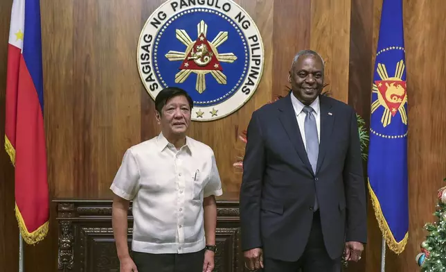 U.S. Defense Secretary Lloyd Austin, right, and Philippine President Ferdinand Marcos Jr. pose for a photograph during a courtesy call at the Malacanang Palace in Manila, Philippines Monday, Nov. 18, 2024. (AP Photo/Gerard Carreon, Pool)