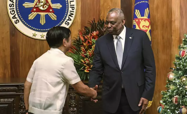 U.S. Defense Secretary Lloyd Austin, right, shakes hands with Philippine President Ferdinand Marcos Jr. during a courtesy call at the Malacanang Palace in Manila, Philippines Monday, Nov. 18, 2024. (AP Photo/Gerard Carreon, Pool)