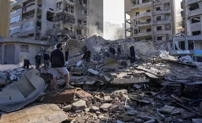 Residents check the site of an Israeli airstrike in Tayouneh, Beirut, Lebanon, Friday, Nov. 15, 2024. (AP Photo/Hassan Ammar)