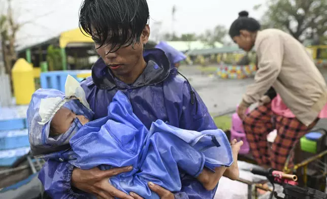 Residents arrive at a school used as a temporary evacuation center as they evacuate their homes at Santa Ana, Cagayan province, northern Philippines as Typhoon Usagi approaches Thursday, Nov. 14, 2024. (AP Photo/Noel Celis)