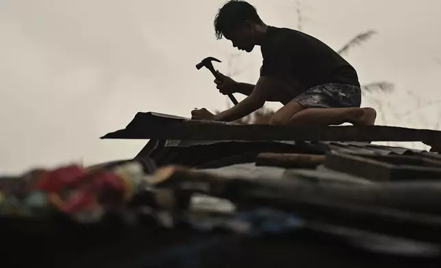 A resident reinforces his roof in Santa Ana, Cagayan Province, northern Philippines as they anticipate Typhoon Usagi to hit their area Thursday, Nov. 14, 2024. (AP Photo/Noel Celis)