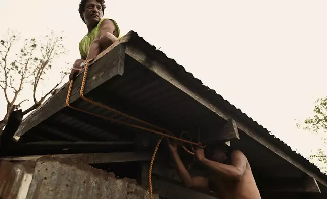 Residents reinforce the roof of their house in Santa Ana, Cagayan Province, northern Philippines as they anticipate Typhoon Usagi to hit their area Thursday, Nov. 14, 2024. (AP Photo/Noel Celis)