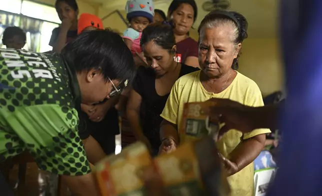 Residents receive relief goods at a school used as an evacuation center in Santa Ana, Cagayan province, northern Philippines as Typhoon Usagi approaches Thursday, Nov. 14, 2024. (AP Photo/Noel Celis)