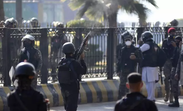 A police officer fires warning shots in the air during clashes with supporters of imprisoned former premier Imran Khan's Pakistan Tehreek-e-Insaf party, in Islamabad, Pakistan, Tuesday, Nov. 26, 2024. (AP Photo/W.K. Yousufzai)