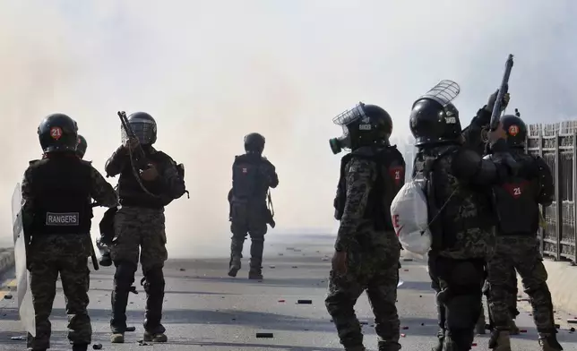 Paramilitary soldiers fire rubber bullets and tear gas shells to disperse supporters of imprisoned former premier Imran Khan's Pakistan Tehreek-e-Insaf party, during clashes at D-Chowk square close to Red Zone, which is an area that houses key government buildings, in Islamabad, Pakistan, Tuesday, Nov. 26, 2024. (AP Photo/Ehsan Shahzad)