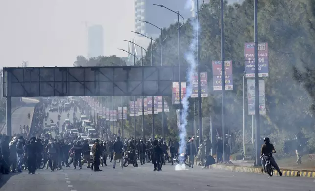 Police fire tear gas to disperse supporters of imprisoned former premier Imran Khan's Pakistan Tehreek-e-Insaf party, at D-Chowk square close to Red Zone, which is an area that houses key government buildings, in Islamabad, Pakistan, Tuesday, Nov. 26, 2024. (AP Photo/W.K. Yousufzai)