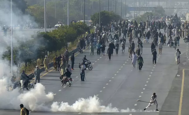 Police fire tear gas shell to disperse supporters of imprisoned former premier Imran Khan's Pakistan Tehreek-e-Insaf party, during clashes, in Islamabad, Pakistan, Tuesday, Nov. 26, 2024. (AP Photo/Irtisham Ahmed)